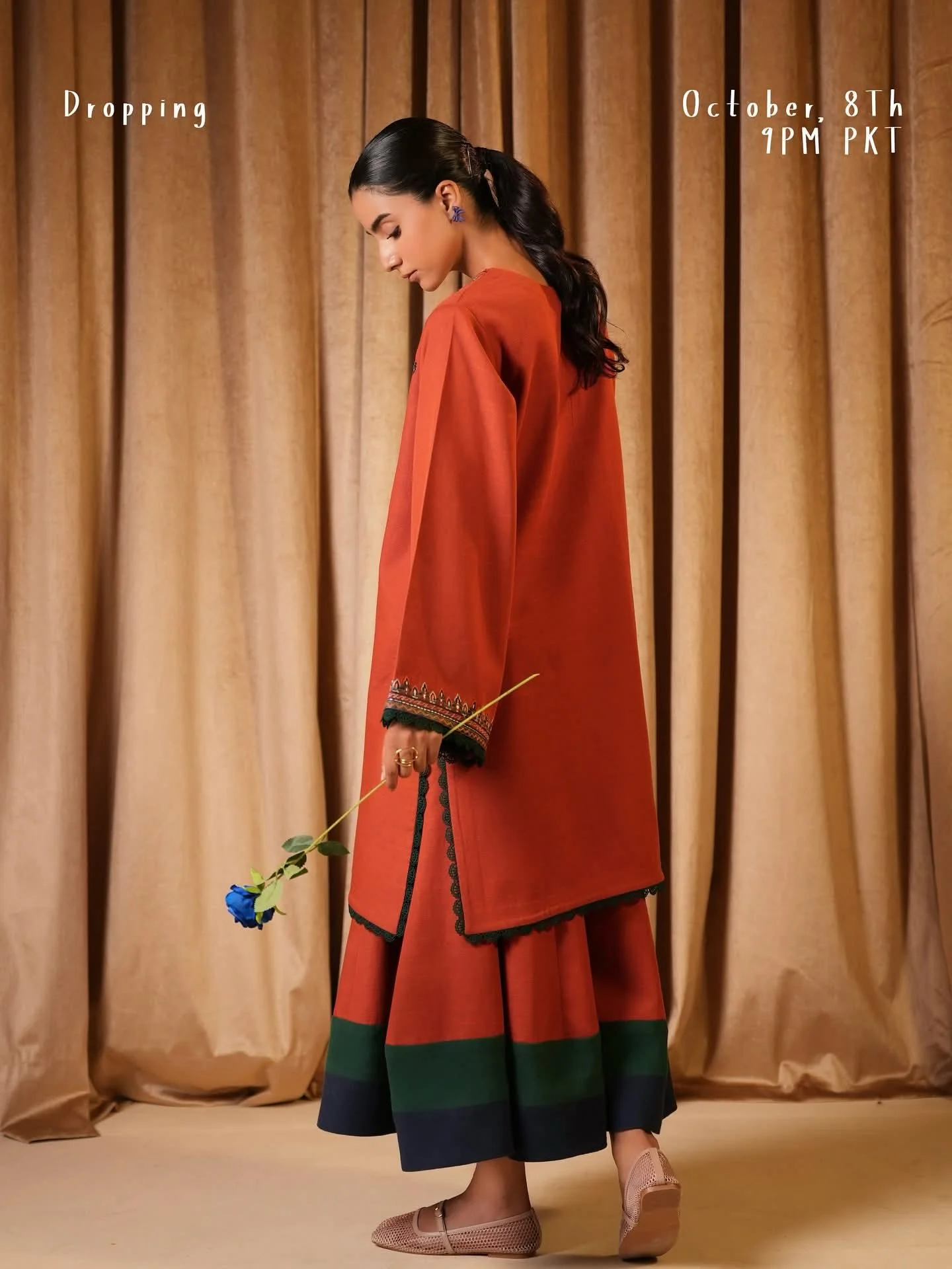 Model wearing rust kurta set for women with green contrast border and minimal embroidery, elegant eastern outfit by Shanzayb
